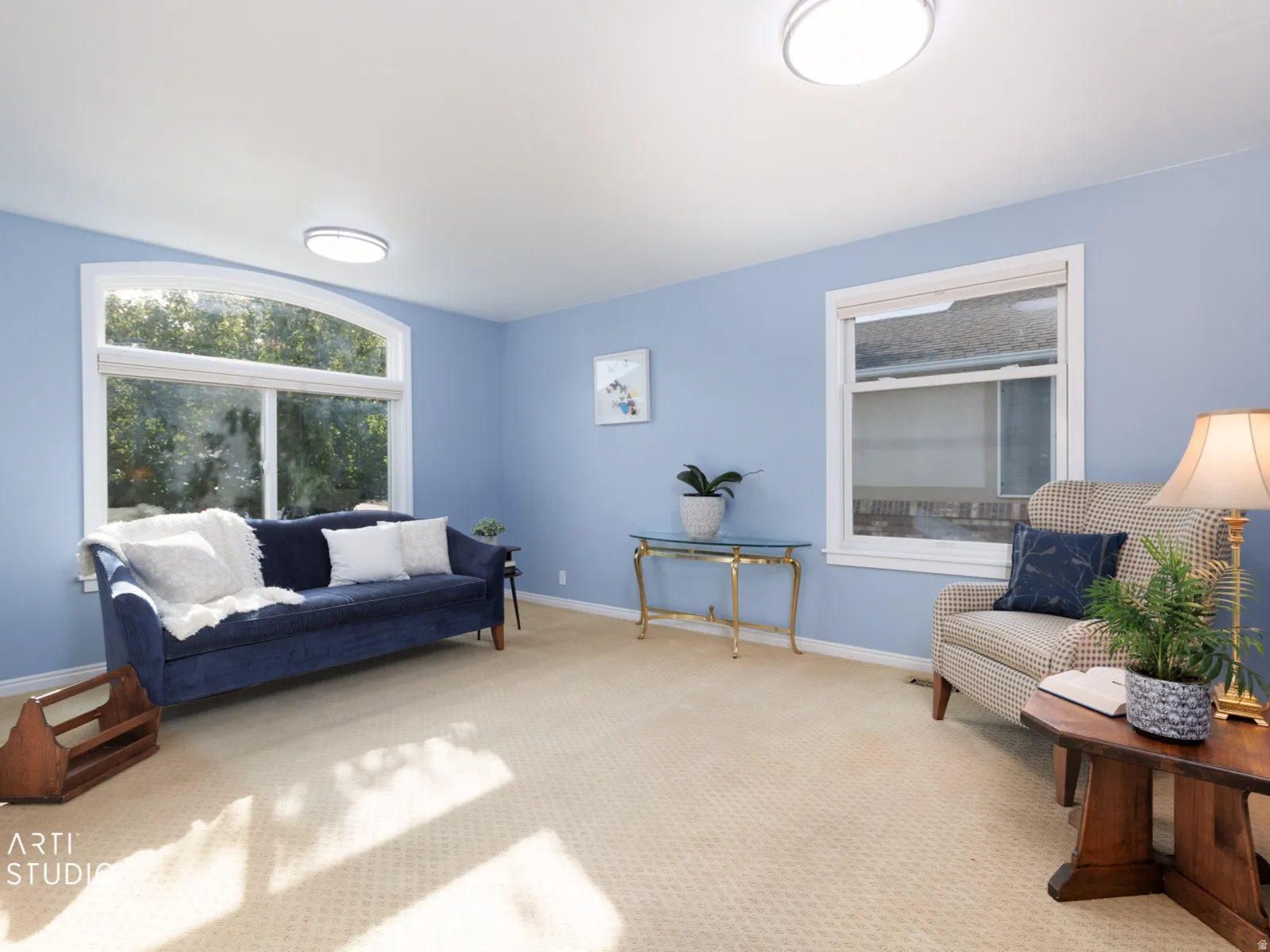 Arched window, recessed lighting, and light-toned carpeting