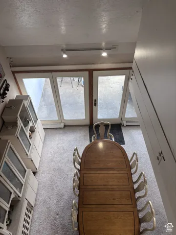 Built-in cabinetry with glass-front uppers and lower storage, track lighting fixtures, and a pair of white French doors with dark hardware