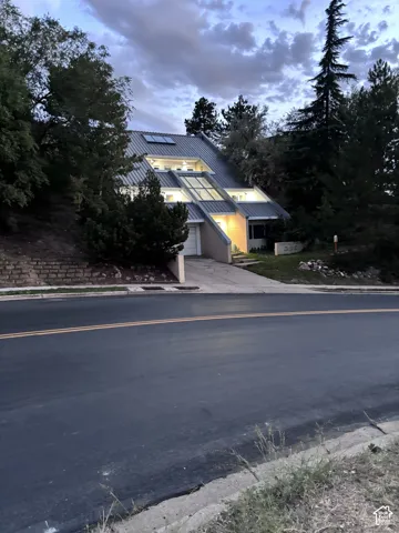 Architectural design with a distinctive sloped roofline, integrated skylights, and multiple exterior lighting fixtures