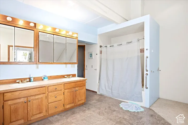 Dual vanity with wood-finish cabinetry, integrated sinks, and individual mirrors
