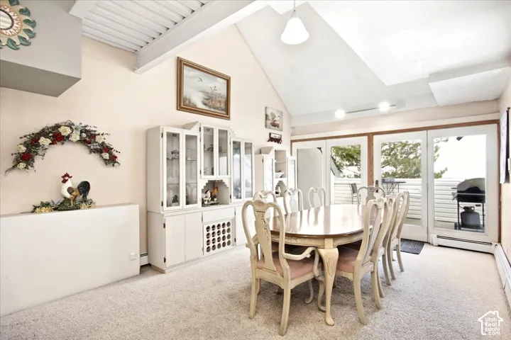 Vaulted ceilings with exposed beams, built-in display cabinetry, and a full wall of glass doors opening to a balcony