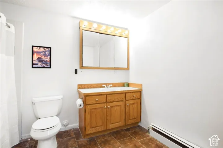 Bathroom featuring a wood-finish vanity with built-in storage, white countertop, and tiled flooring