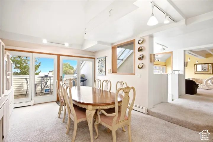 Sliding glass doors leading to an outdoor balcony, a built-in display cabinet, track lighting, and a skylight