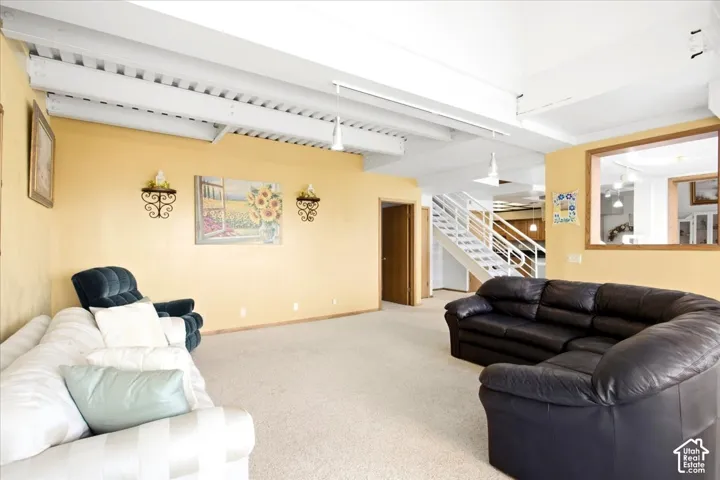 Exposed beam ceiling, light-colored carpeting, warm-toned walls, wood-finish trim, and an internal window opening