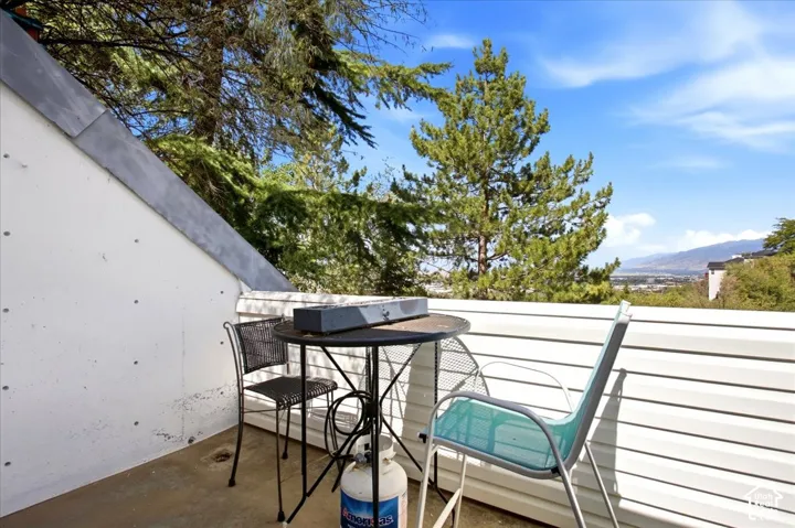 Outdoor balcony featuring a sloped wall and horizontal siding