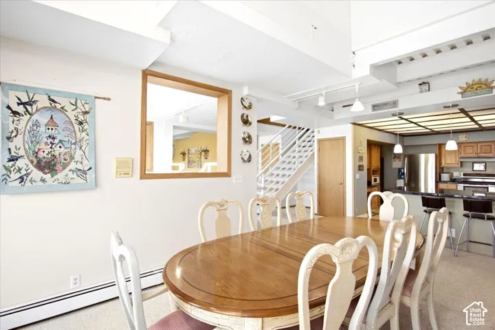 Open-concept dining area featuring a pass-through window and exposed ceiling beams