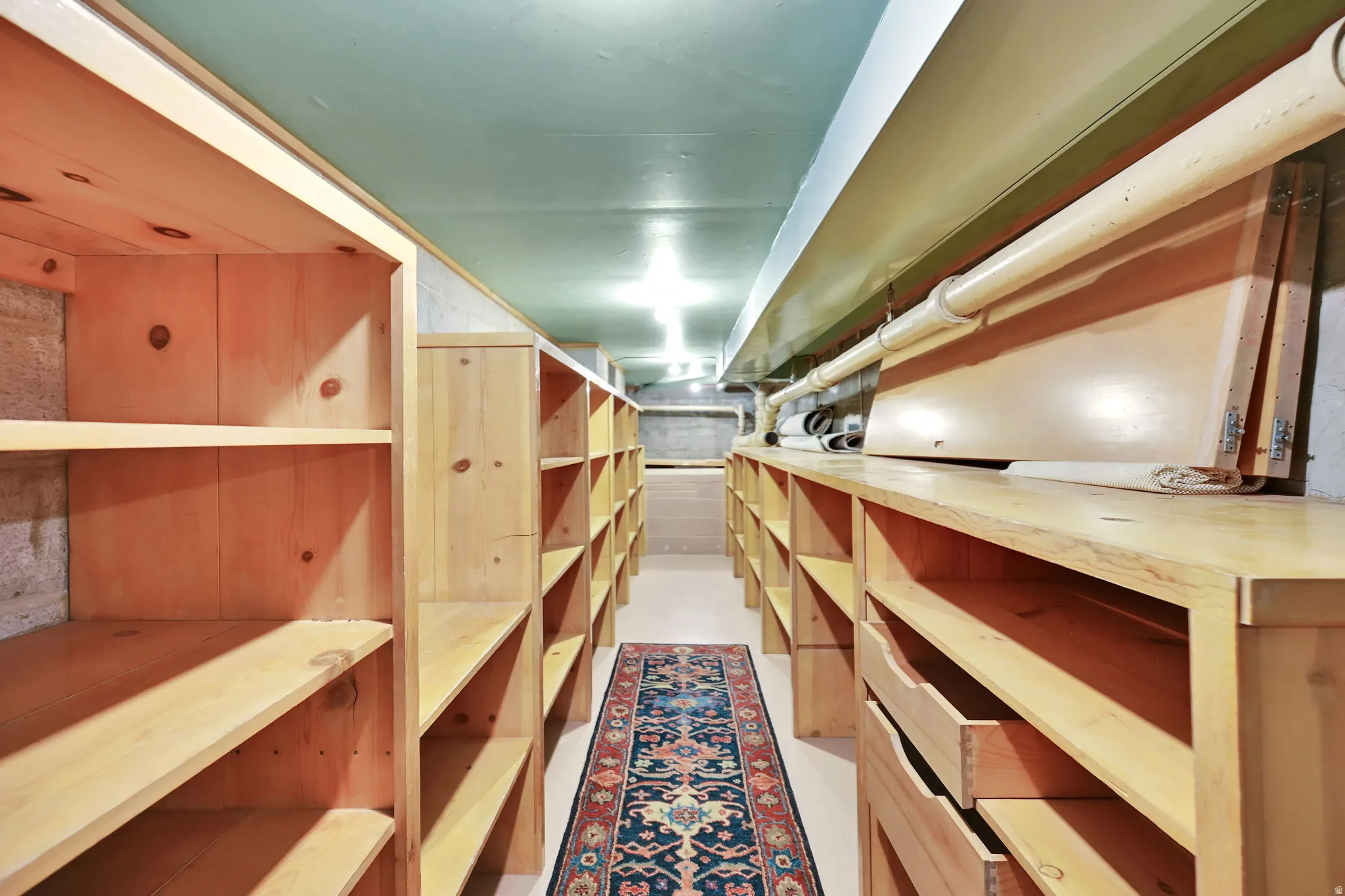 Extensive built-in wood shelving, multiple drawers, and overhead lighting provide ample storage
