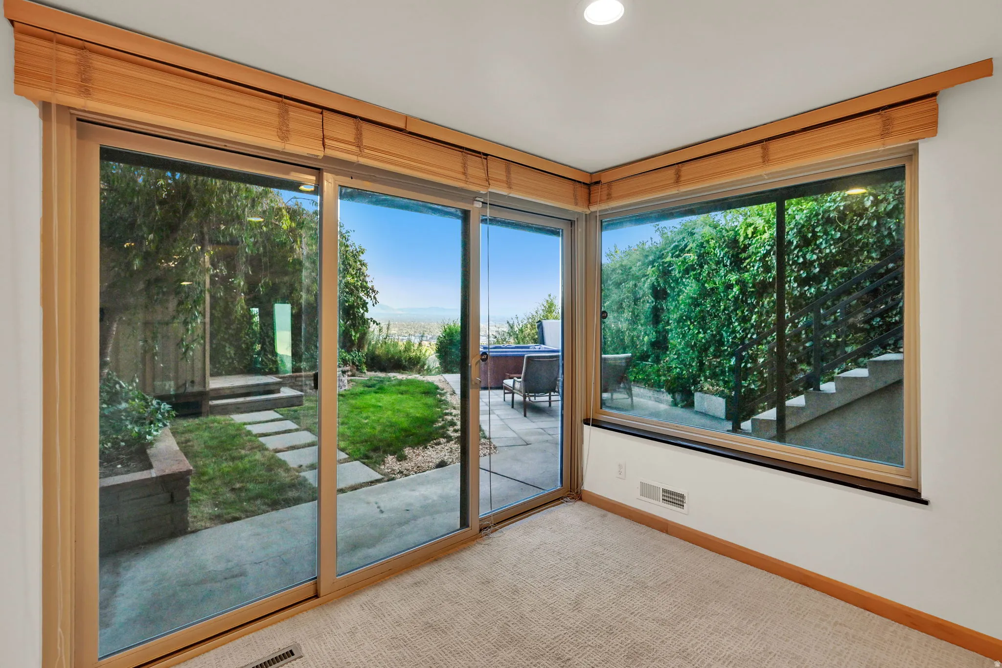 Sliding glass doors opening to an outdoor patio with a hot tub