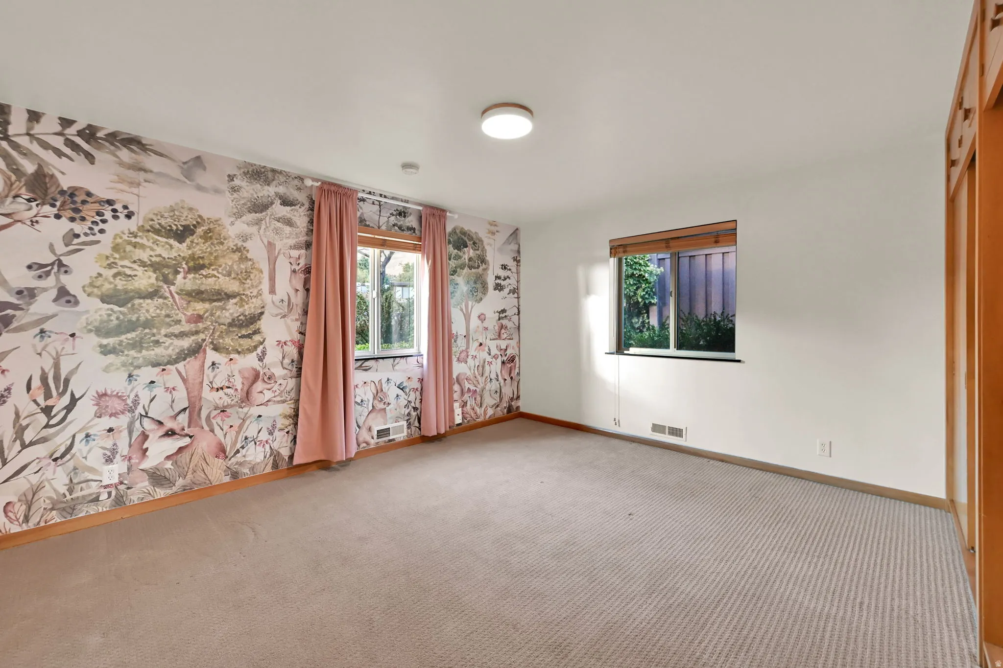 Textured carpeting, wood-finish baseboards, recessed lighting, and dual windows with privacy blinds