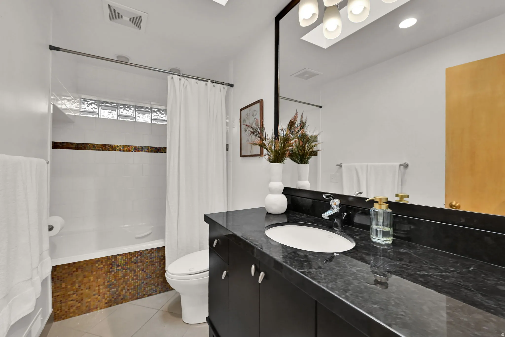 Full Bath vanity with dark countertop and undermount sink