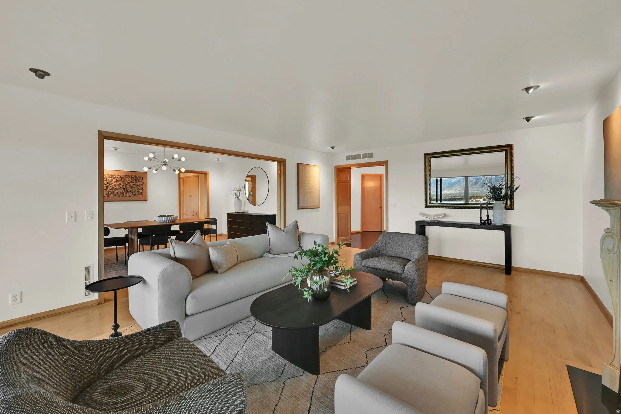 Hardwood-style flooring throughout, an open doorway with wood trim, recessed lighting, and a decorative fireplace surround