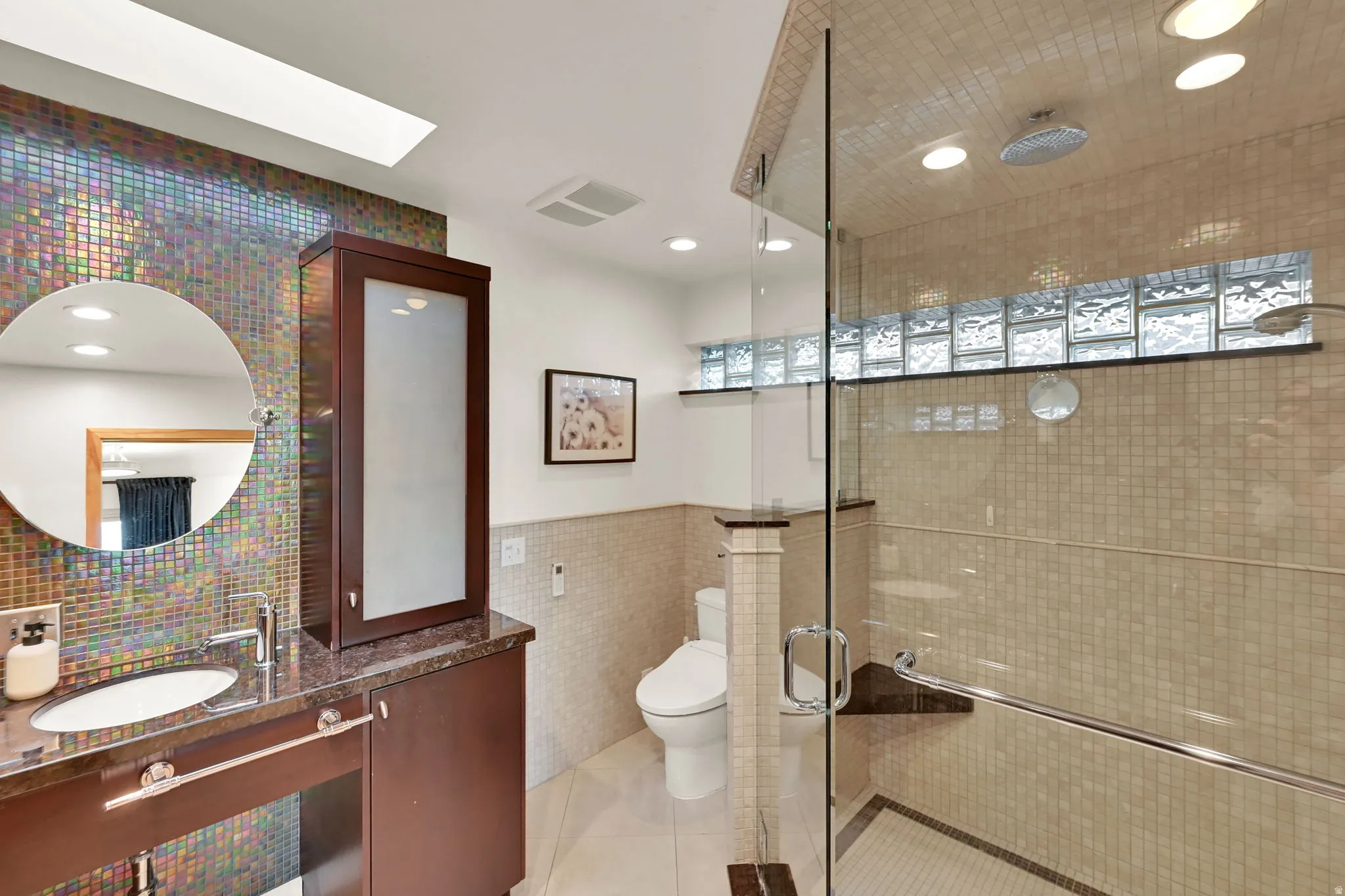 Skylight and recessed lighting illuminate the bathroom