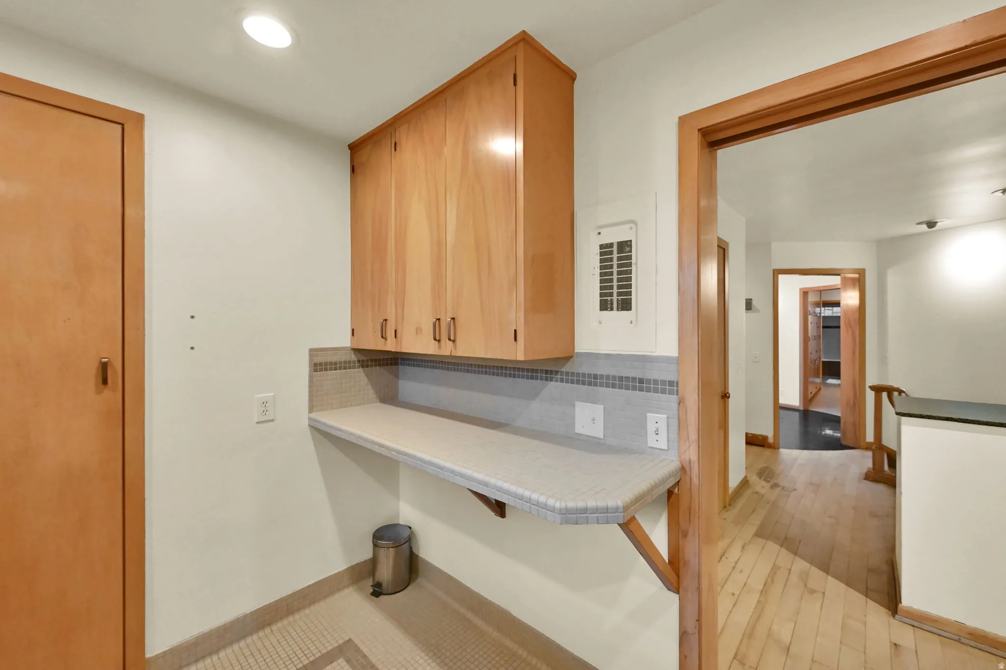 Upper cabinetry with wood-finish doors, a tiled backsplash, and an integrated countertop