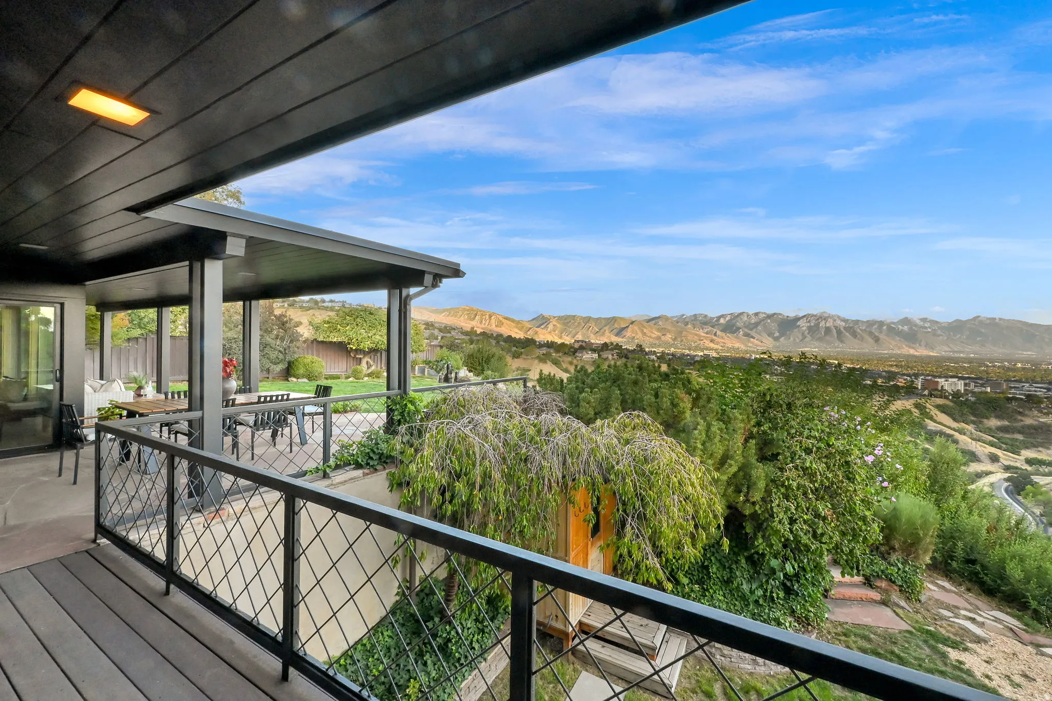 Spacious outdoor deck with wood-look flooring and a metal railing