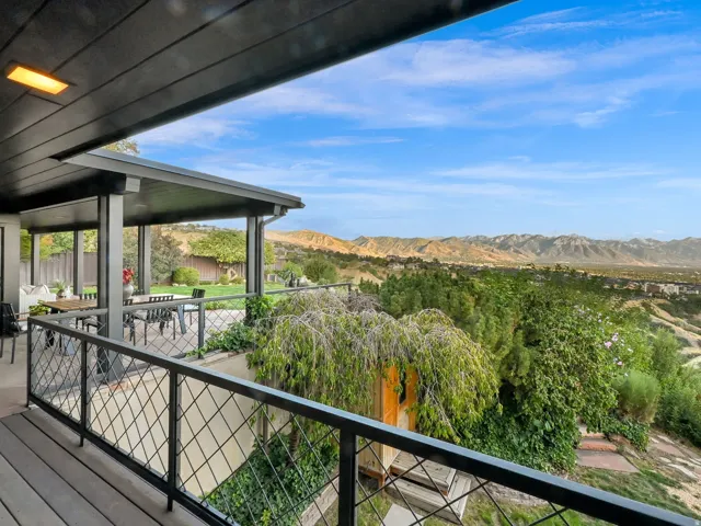 Spacious outdoor deck with wood-look flooring and a metal railing