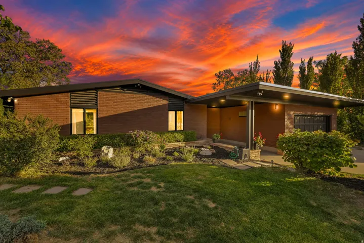 Mid-century modern residence featuring brick and dark panel siding