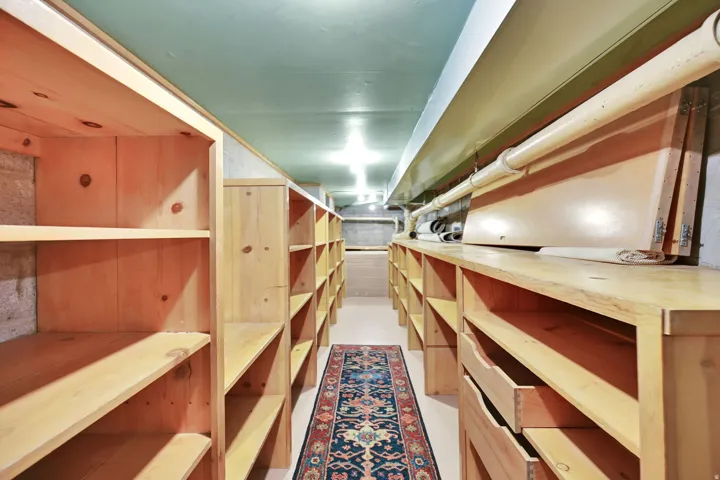 Extensive built-in wood shelving, multiple drawers, and overhead lighting provide ample storage