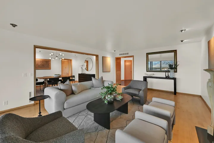 Hardwood-style flooring throughout, an open doorway with wood trim, recessed lighting, and a decorative fireplace surround
