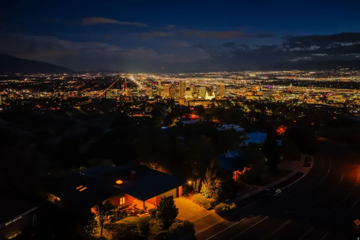 Cityscape backdrop featuring expansive urban lights and distant mountains