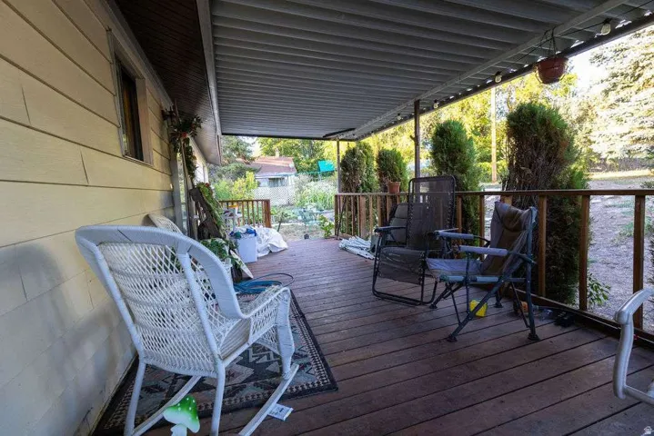 Covered wood-finish deck with a slatted roof and wood railings