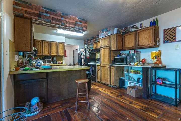 Wood-finish flooring, wood cabinetry, and a peninsula countertop