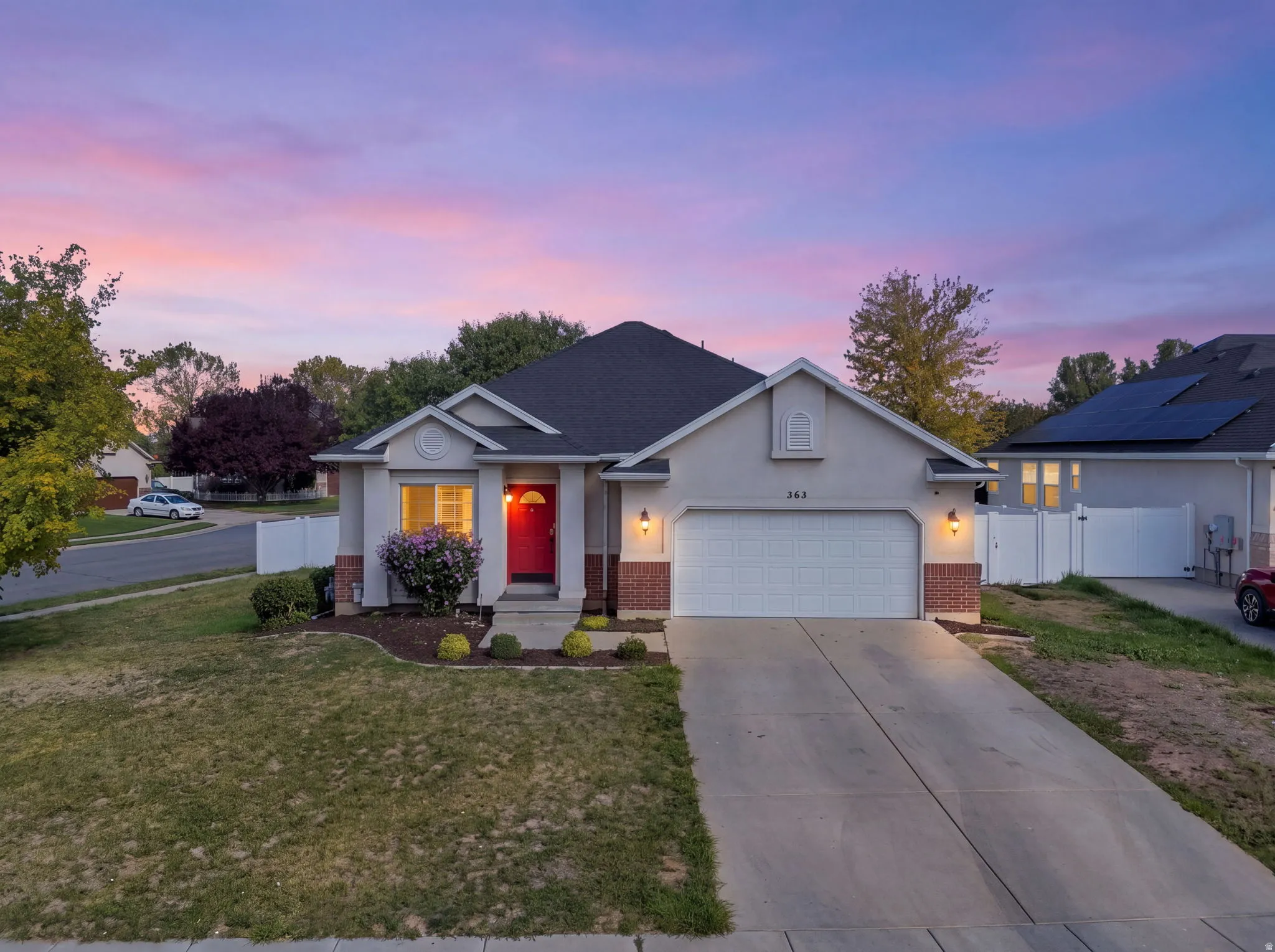 Single-story residence featuring a stucco and brick facade, an attached two-car garage, and a concrete driveway