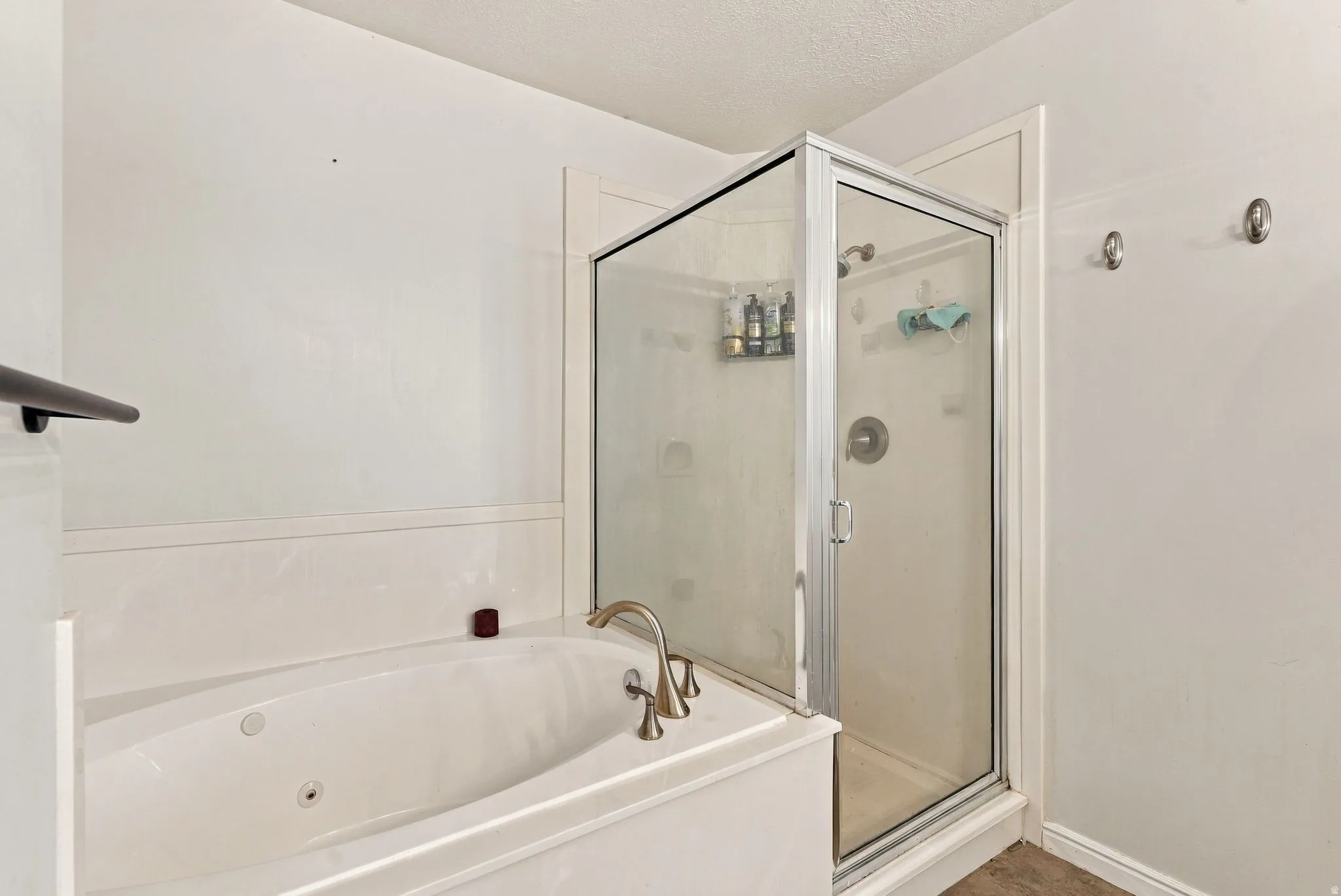 White soaking tub with deck-mounted bronze-finish faucet
