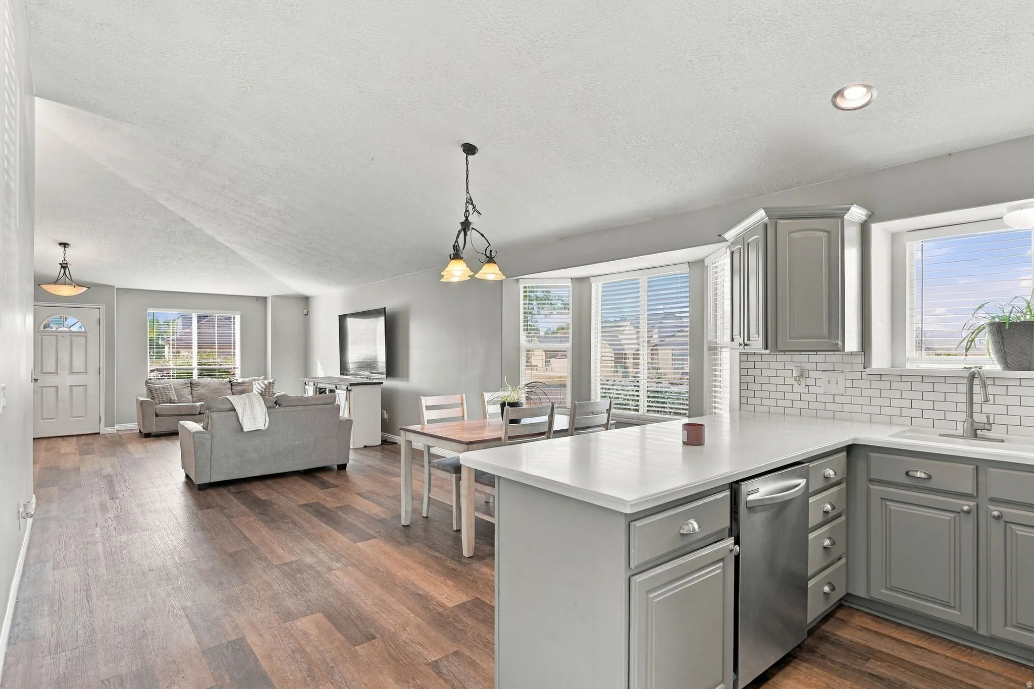 Kitchen featuring gray cabinetry, white countertops, subway tile backsplash, and stainless steel appliances