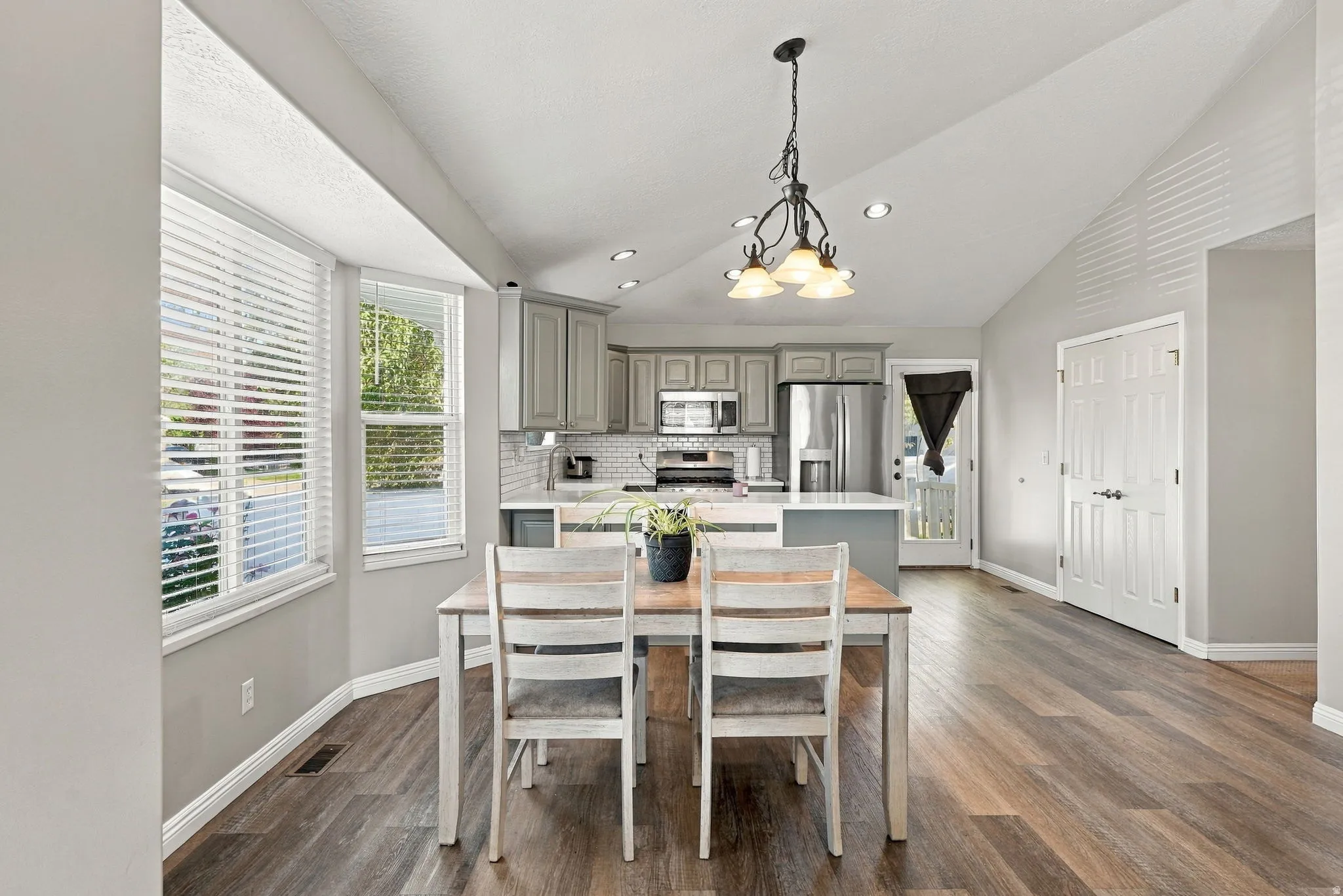 Vaulted ceilings, wood-finish flooring, recessed lighting, shaker-style cabinetry, and stainless steel appliances