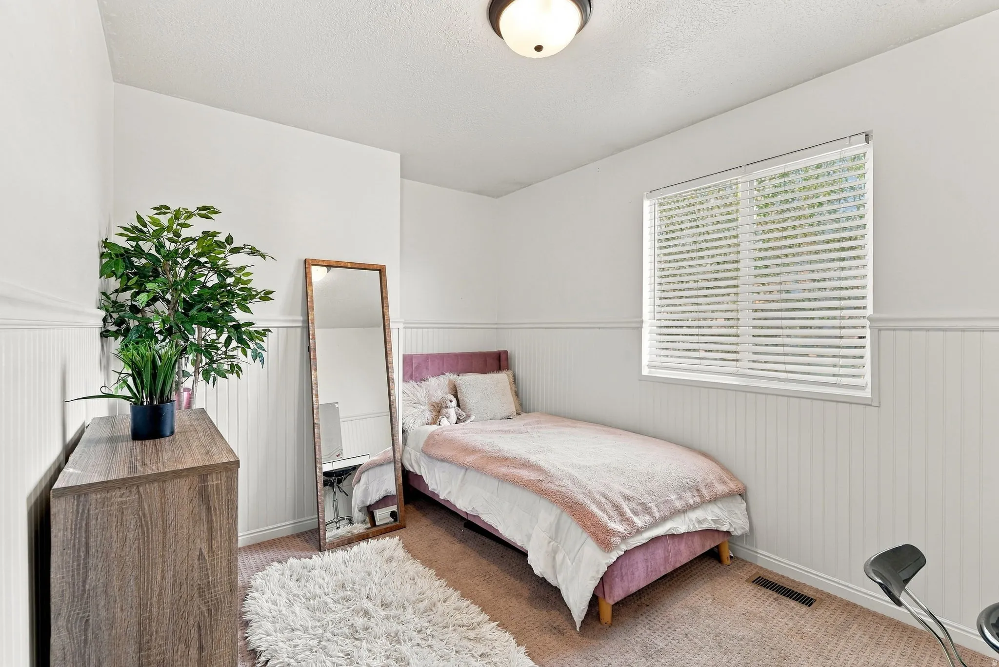 Neutral wall color with wainscoting detail and carpeted flooring