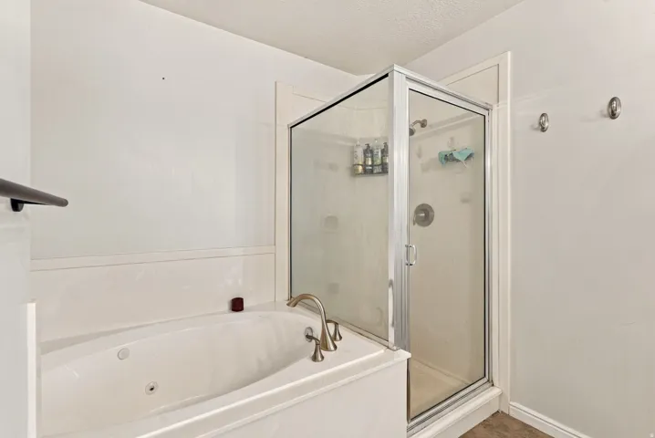 White soaking tub with deck-mounted bronze-finish faucet