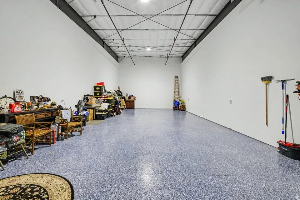 Spacious interior with high ceilings, white walls, and a blue speckled floor finish