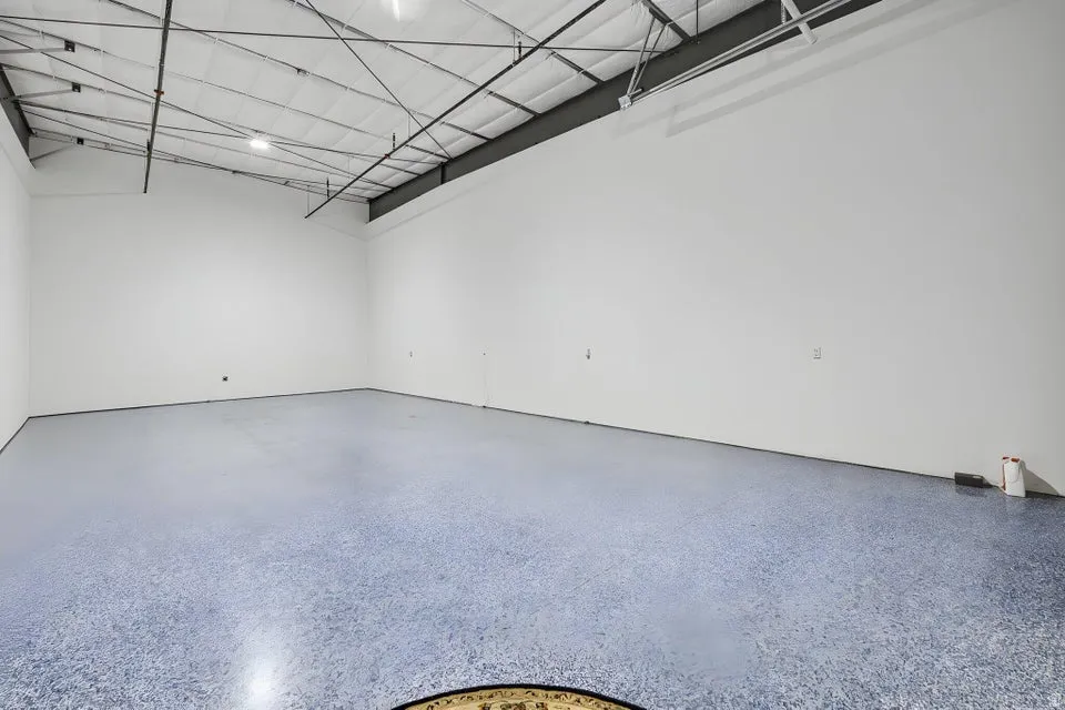 Spacious interior with high ceilings, exposed structural beams, and recessed lighting
