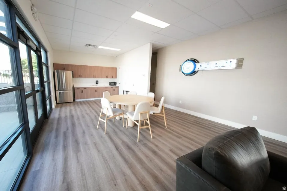 Wood-finish flooring throughout, full-height windows, built-in cabinetry, and stainless steel appliances