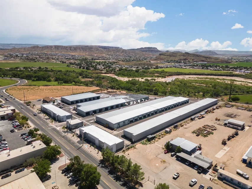 Multiple industrial buildings with grey metal roofing and large roll-up doors