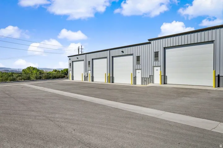 Corrugated metal exterior with multiple large roll-up doors and pedestrian entryways