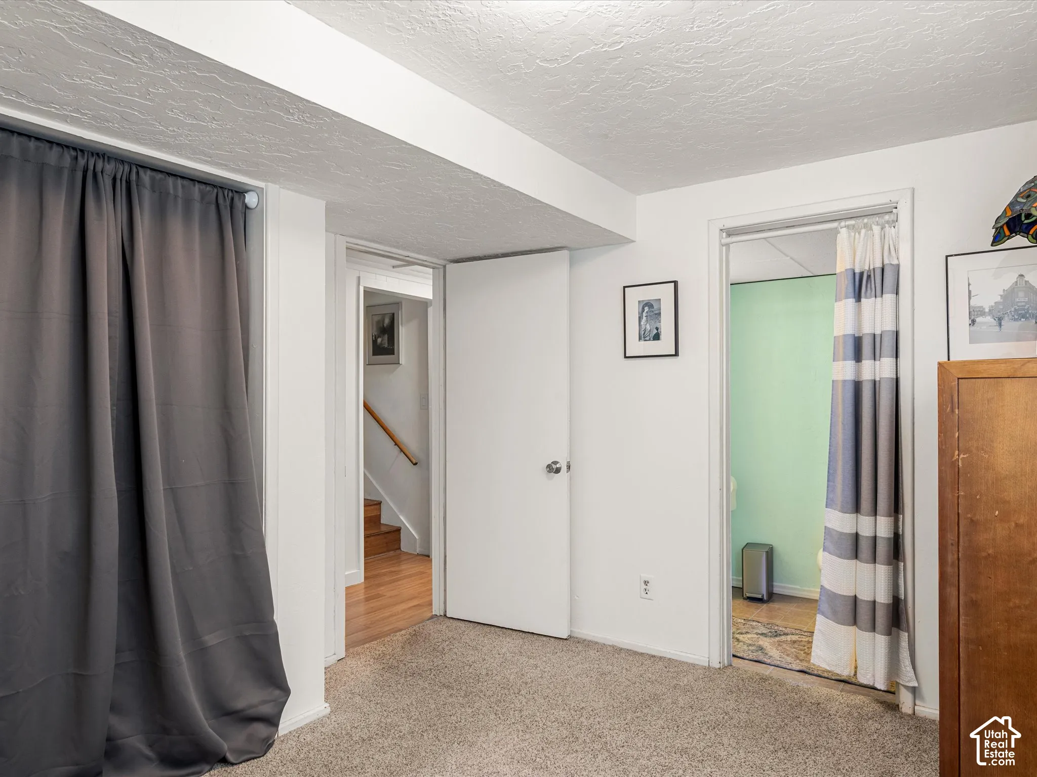 Carpeted flooring, white interior walls, white ceiling, and a solid interior door
