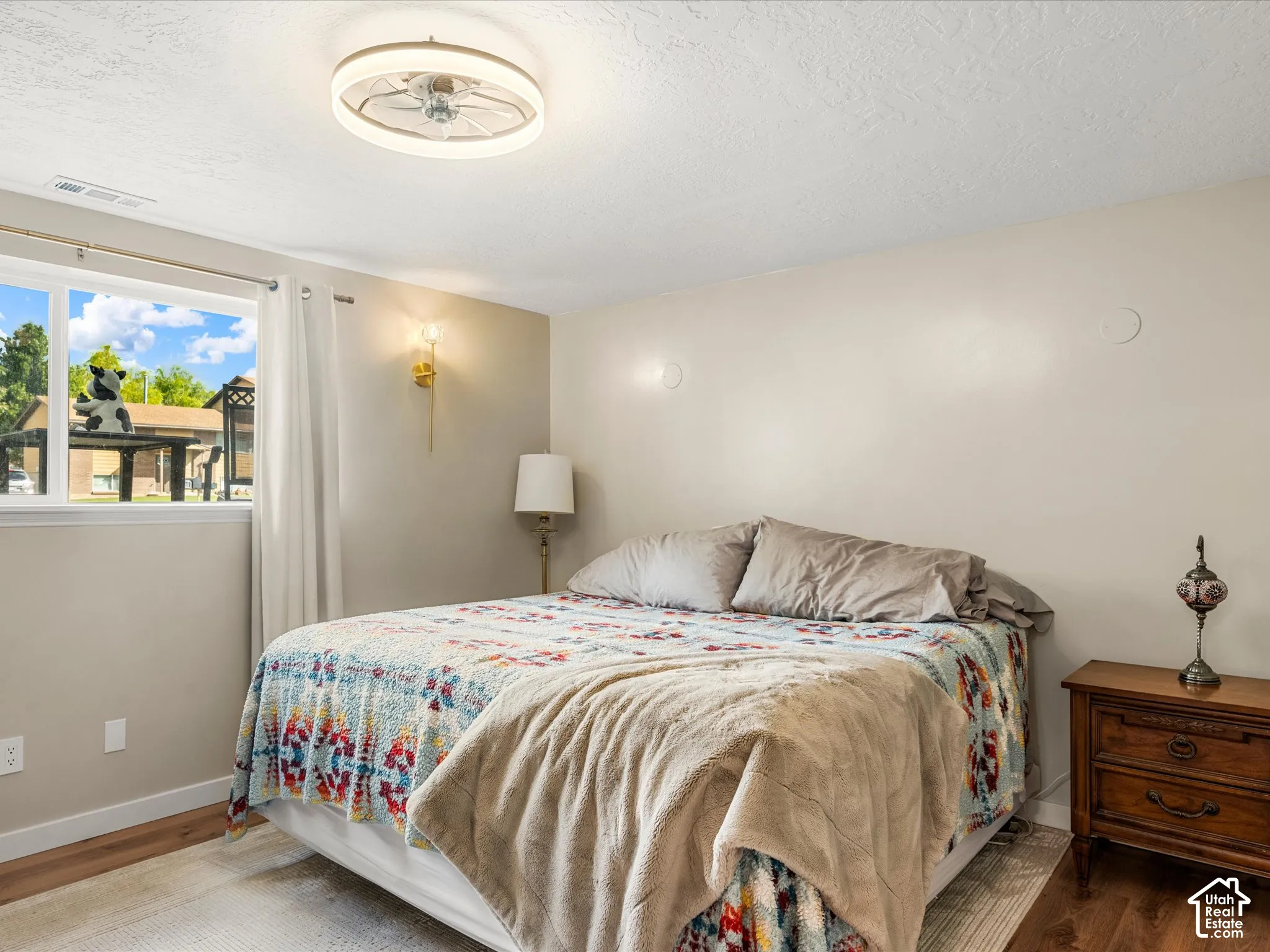 Wood-finish flooring, white trim, and a window with white casing