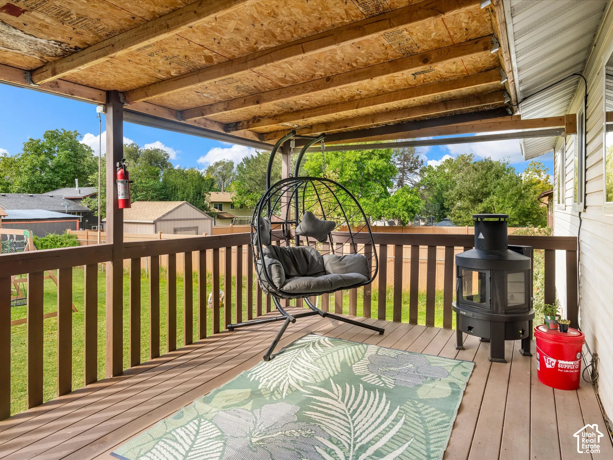 Covered outdoor deck with wood-finish flooring and a wood railing