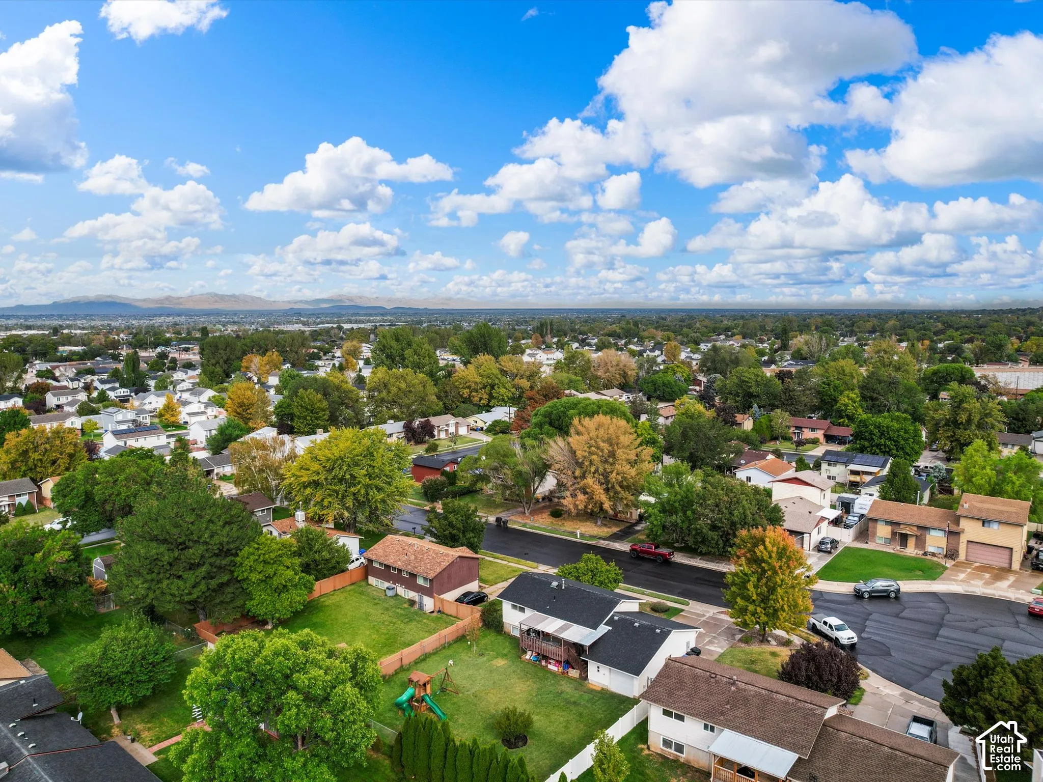 Expansive neighborhood setting with established homes, mature trees, and mountainous scenery