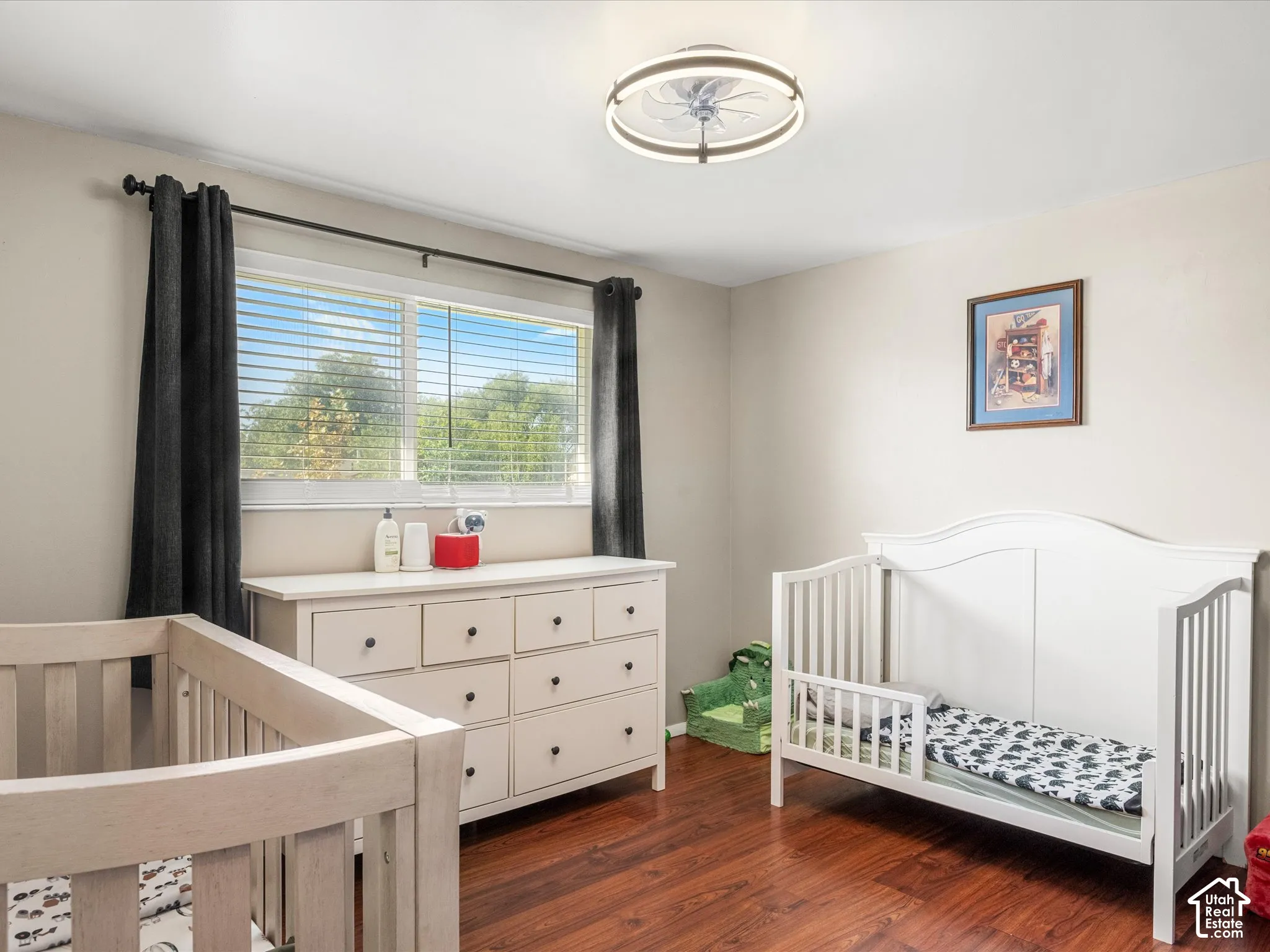 Hardwood-finish flooring, recessed lighting, and a window with blinds and dark-hued curtains