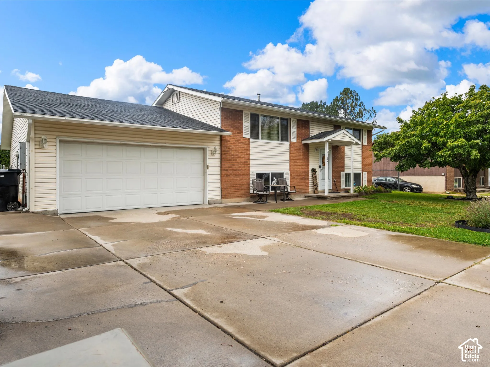 Two-story residence featuring brick and siding facade, covered front entry, attached garage, and paved driveway