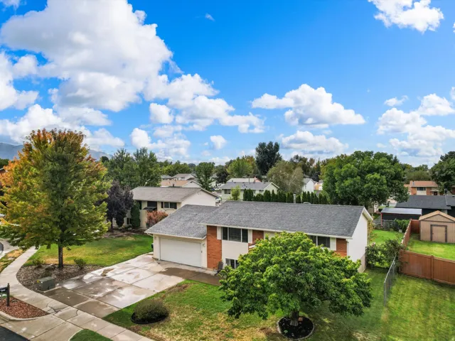 Split-level residence featuring an attached two-car garage, mature landscaping, and a fenced backyard