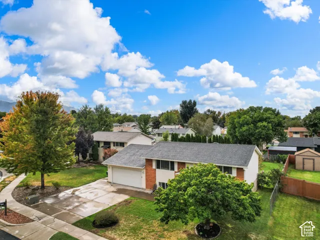 Split-level residence featuring an attached two-car garage, mature landscaping, and a fenced backyard