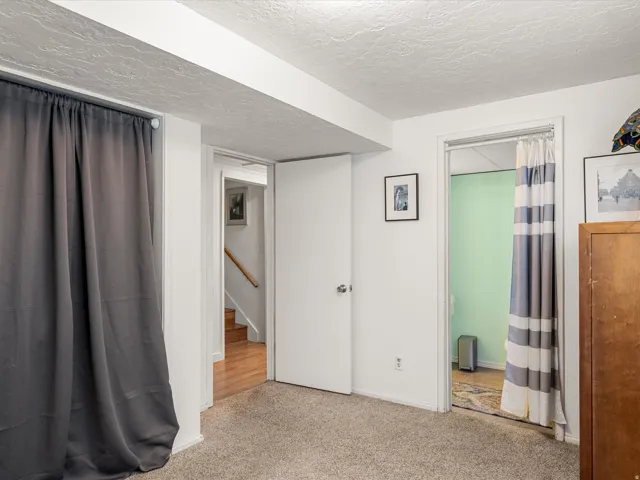 Carpeted flooring, white interior walls, white ceiling, and a solid interior door