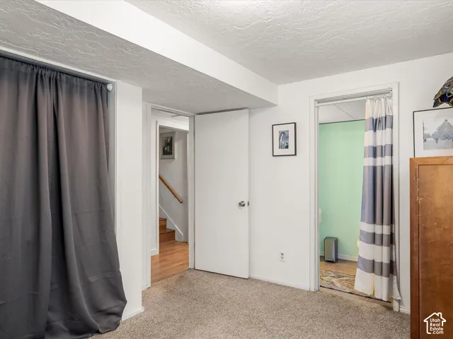 Carpeted flooring, white interior walls, white ceiling, and a solid interior door