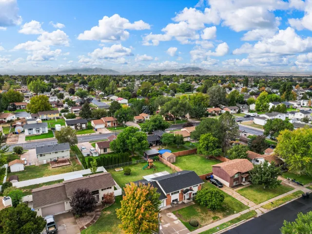 Expansive suburban neighborhood featuring numerous single-family homes, mature trees, and mountainous surroundings