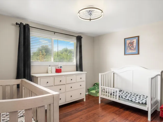 Hardwood-finish flooring, recessed lighting, and a window with blinds and dark-hued curtains