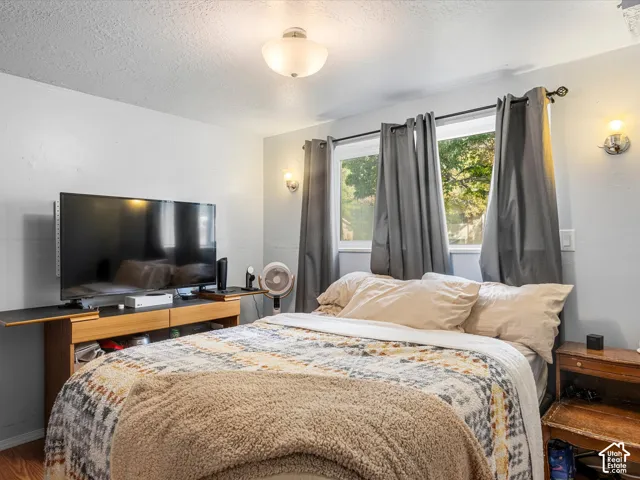 Recessed window with exterior scenery, wall-mounted sconce lighting, and wood-finish flooring