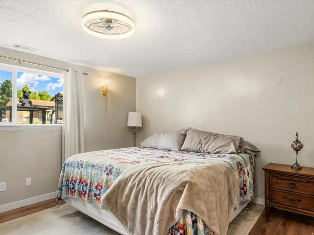 Wood-finish flooring, white trim, and a window with white casing
